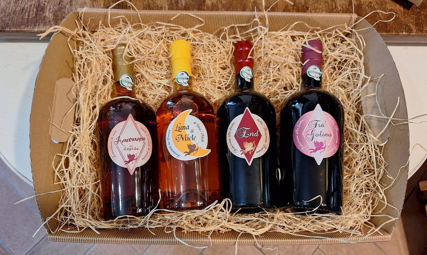 Cesto natalizio con liquori artigianali. Bottiglie decorate, idea regalo originale. Prodotti tipici italiani.