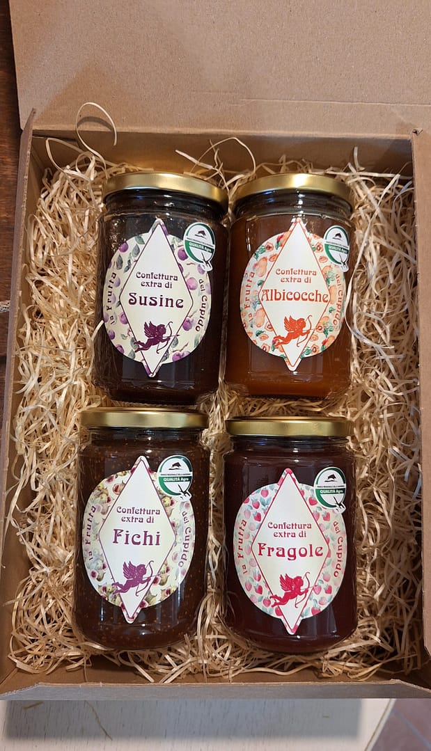 Christmas basket with homemade jams: plums, apricots, figs and strawberries. Delicious and genuine gift idea.